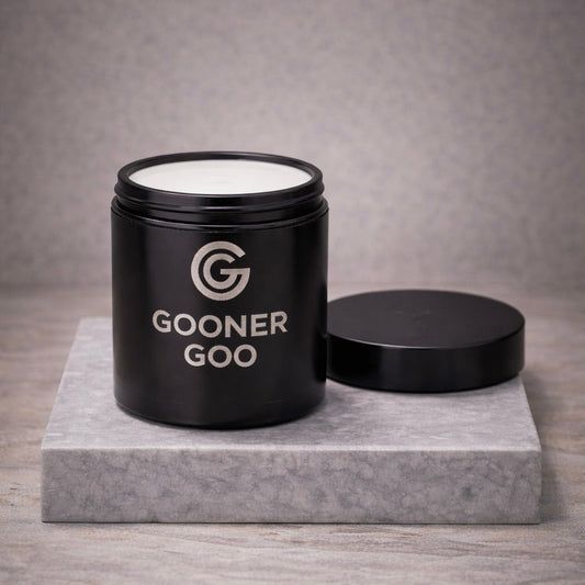 Open black container with product inside and 'Gooner Goo' branding on a gray surface and background.