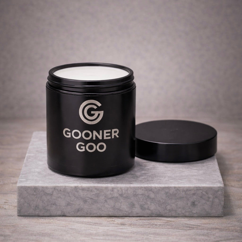 Open black container with product inside and 'Gooner Goo' branding on a gray surface and background. 
